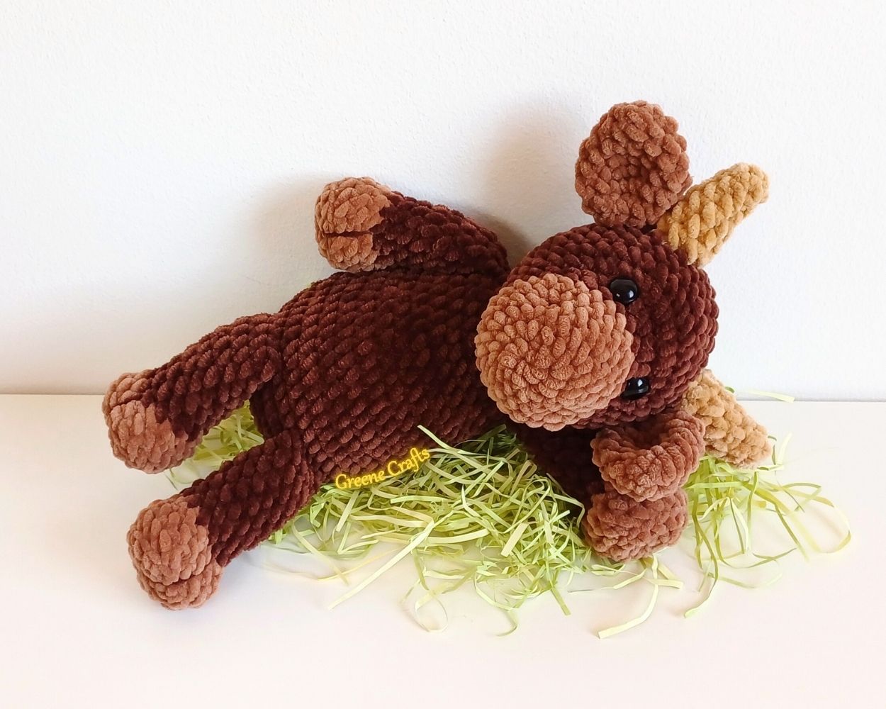 Bandit the Bull crochet plush lying down to show the finished amigurumi design.