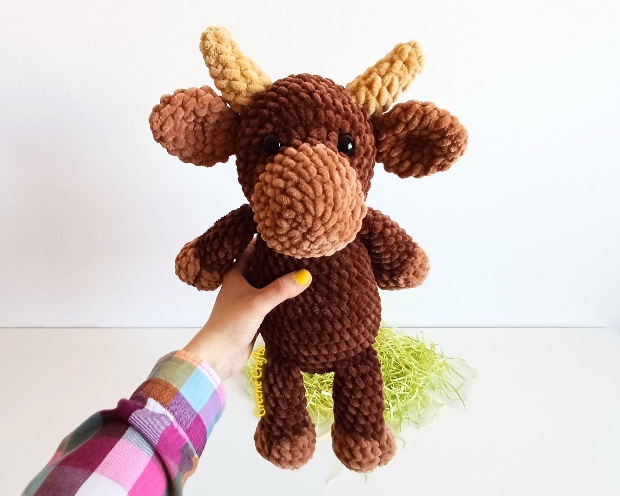 Bandit the Bull crochet toy held in one hand to show the finished size.