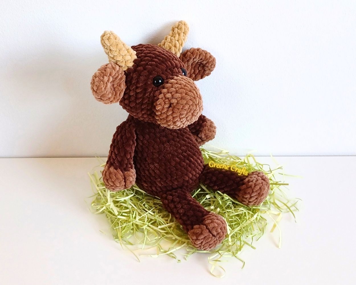 Side view of Bandit the Bull crochet toy showing the body shape and horns.